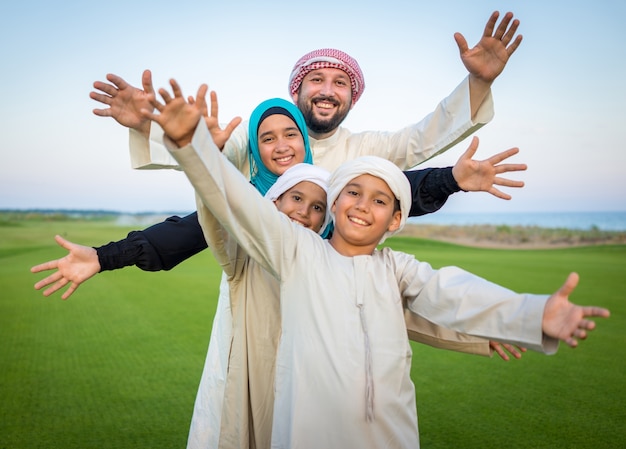 Photo arabic family on green meadow in nature