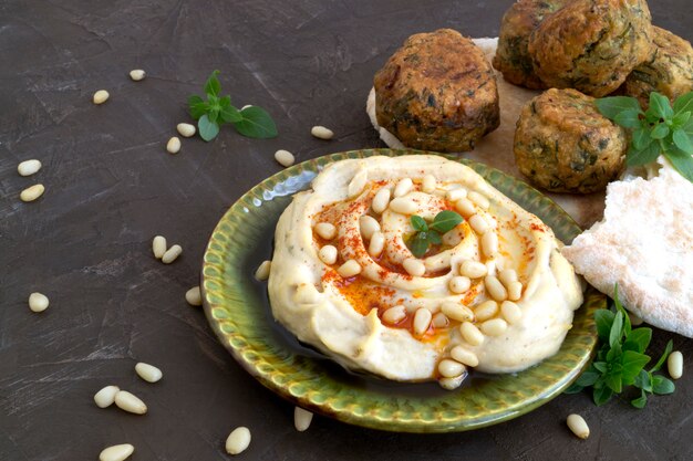 Cibo arabo hummus e falafel su uno sfondo grigio.