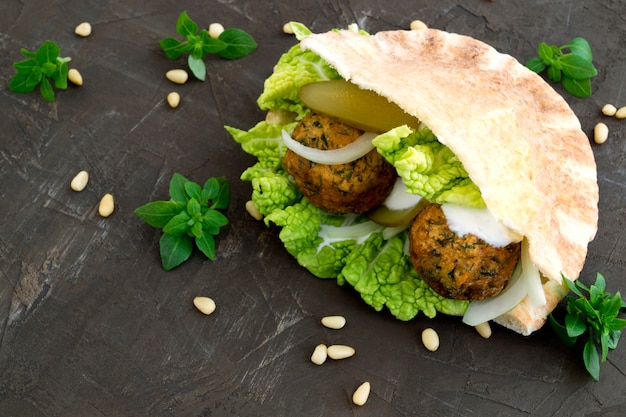 Foto cibo arabo hummus e falafel su uno sfondo grigio.