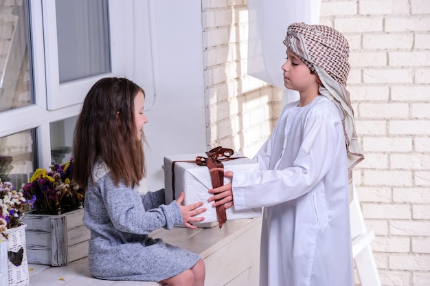 Arabic kids unpacking the gift box.