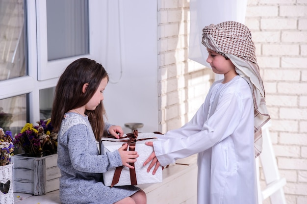 Arabic kids unpacking the gift box.