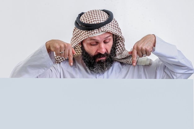 Арабский мужчина держит белый плакат и торчит языком stock photo