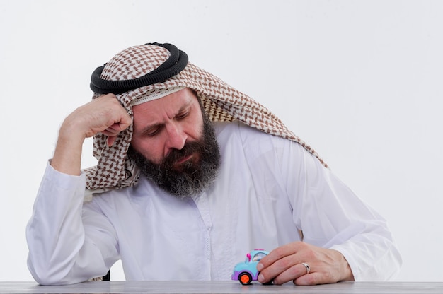 Arabic man plays with toy car