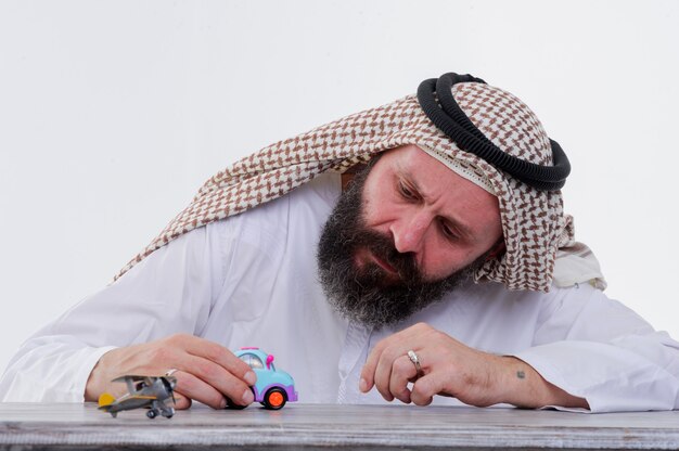 Арабский мужчина играет с игрушечной машиной