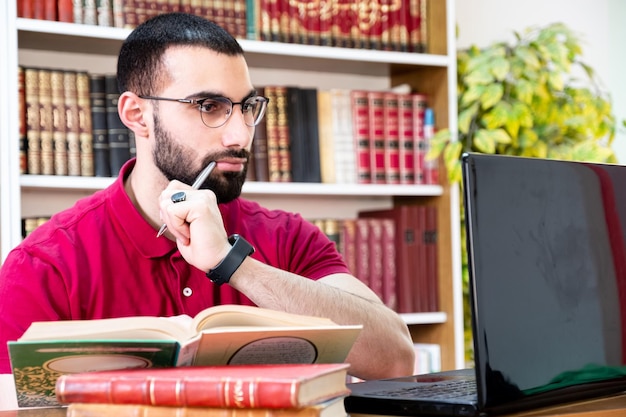 Foto uomo arabo che usa un laptop durante o riunioni per studiare e insegnare attraverso i canali online