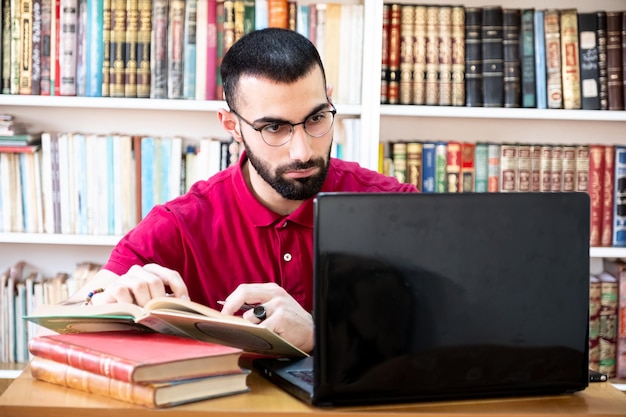 オンラインチャネルを介して勉強や教育のために、または会議中にラップトップを使用しているアラビア人男性