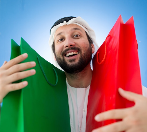 Arabic man with shopping bags smiling
