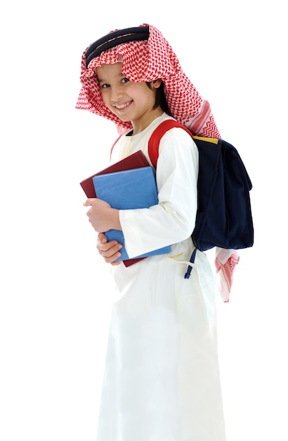 本とバックパックを持つアラビア語の中東の学校の子供