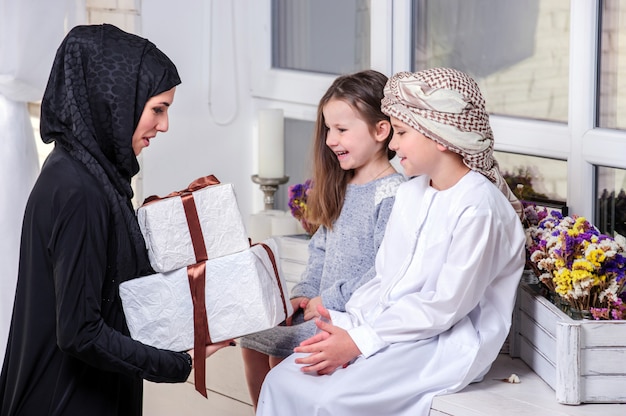 Arabic mother and kids posing with gift.