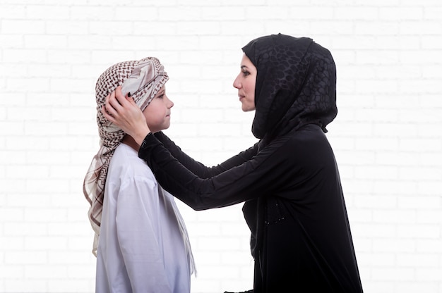 Arabic mother and son posing indoors.