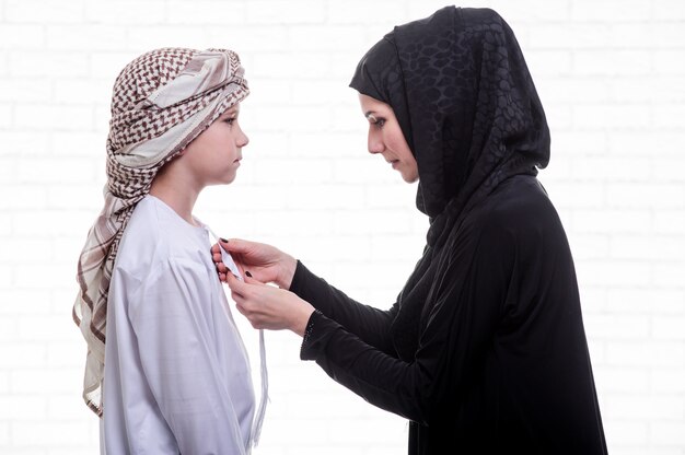 Arabic mother and son posing indoors.