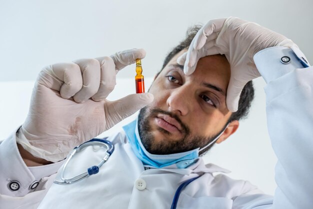 Arabic muslim doctor holding vaccine in his hand