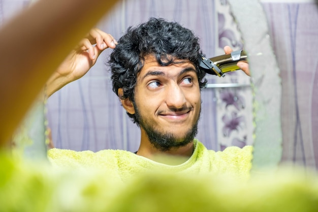 Arabic muslim man cutting his own hair by himself