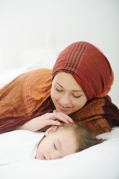 Arabic Muslim mother playing and taking care of her baby