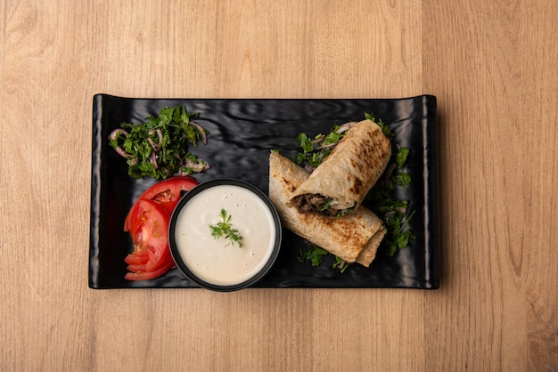 Arabic Shawarma with dip and salad served in dish isolated on table top view of arabian food