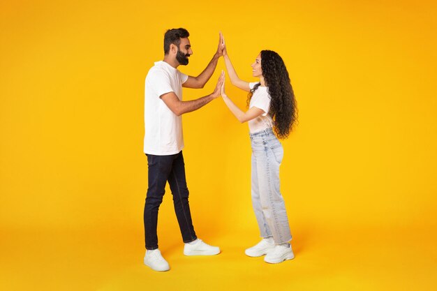 Arabic spouses clapping and holding hands giving high five studio