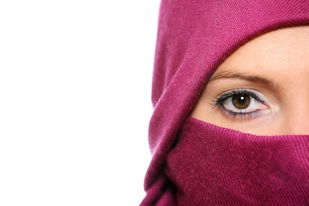 an arabic woman face hidden behind a purple scarf