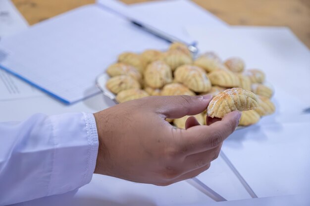 Arabic working colleagues hands eating eid kahk together on working desk