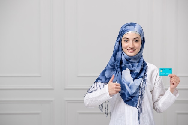 Arabisch meisje gewikkeld hoofd in blauw witte hijab mooie moslim schattige jonge dame met creditcard