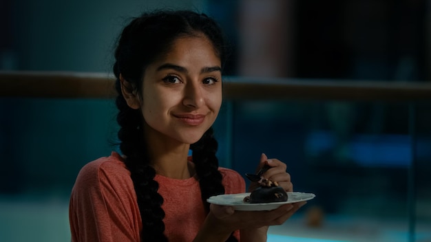 Arabisch meisje hongerige vrouw eet chocoladetaart in coffeeshop en proeft verse bakkerij met eetlust