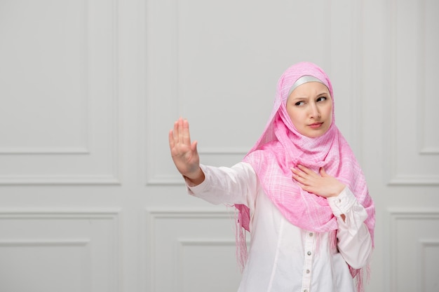 Arabisch meisje schattige mooie jonge moslimvrouw bedekt met mooie roze hijab die laat zien om te stoppen