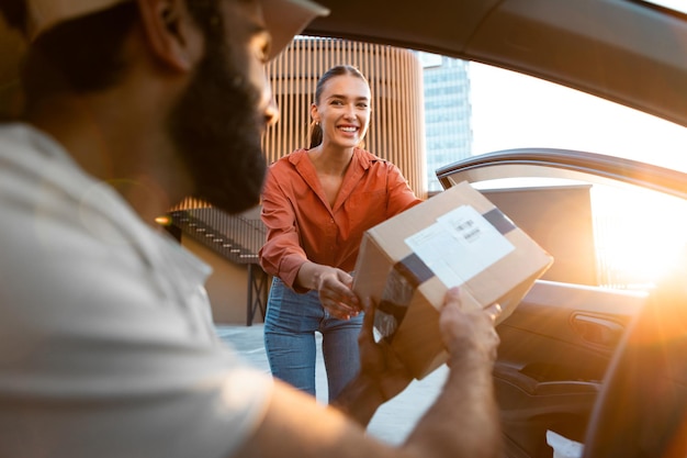 Arabische bezorger die een doos van een klant neemt voor verzending per auto