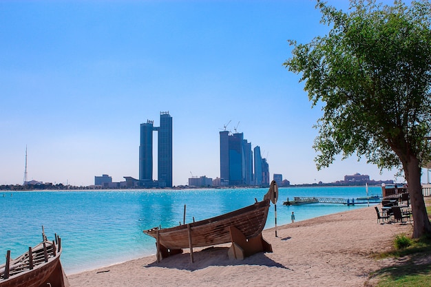 Arabische dhow-boot op de zandige kust voor wolkenkrabbers