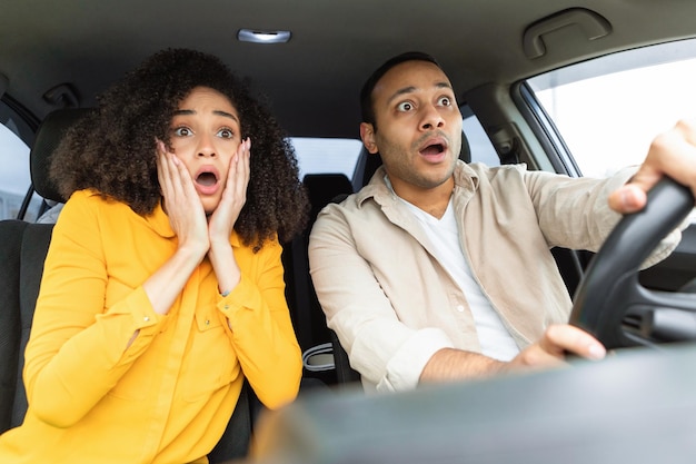 Arabische echtgenoten zitten in de auto en kijken geschokt naar de weg