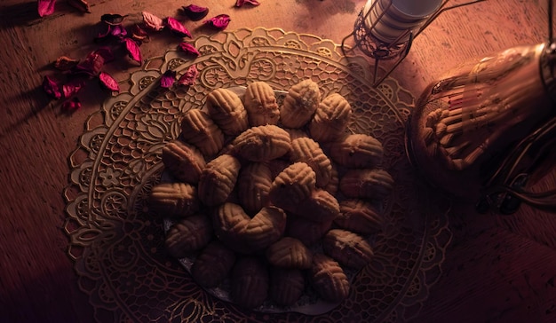 Arabische eid kahk met koffiepot op tafel bij weinig geel licht