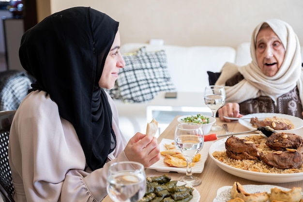 Arabische familie die samen op een houten tafel dineert met vader, moeder, grootvader, grootmoeder en zoon