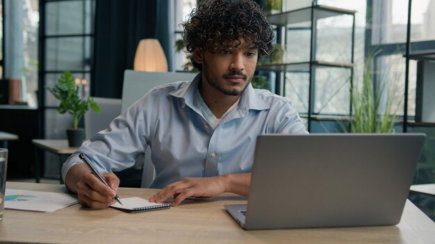 Arabische Indiase Latijnse man zakenman man schrijven zakelijke aantekeningen ideeën in notebook beheren van bedrijven