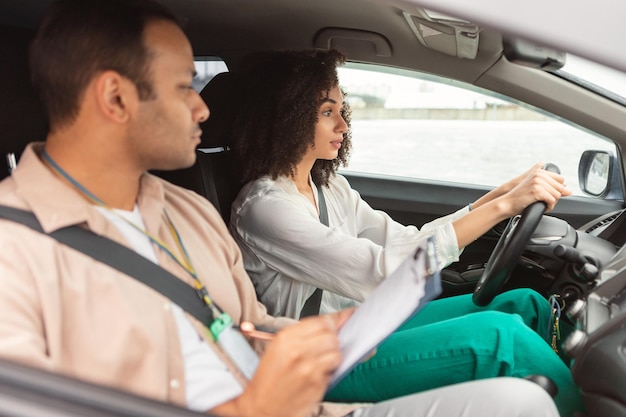 Arabische instructeur man die rijexamen aflegt voor beginnende chauffeur dame