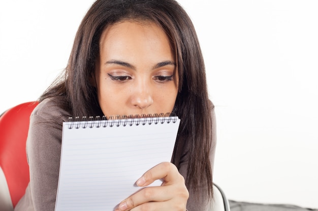 Arabische jonge vrouw die in een notitieboekje schrijft