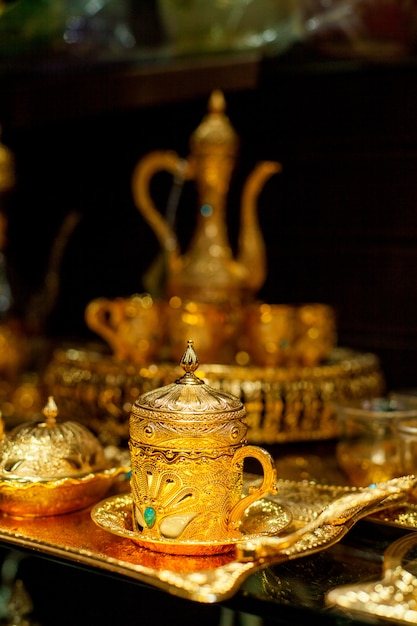 Arabische kop en theepot van goud op de oostelijke markt. Oosterse thee