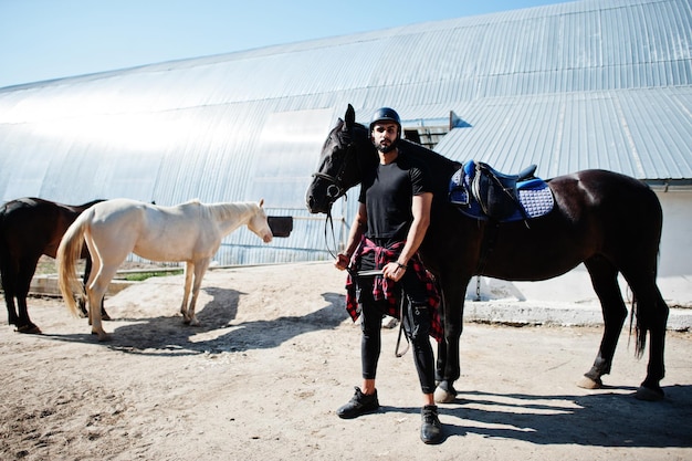 Arabische lange baard man draagt zwarte helm met Arabisch paard