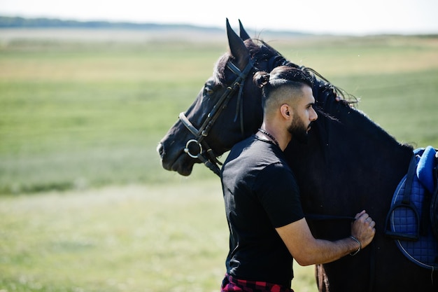 Foto arabische lange baard man slijtage in het zwart met arabisch paard