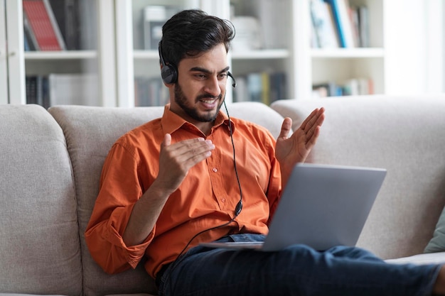 Arabische man CEO werkt vanuit huis met behulp van laptop en headset