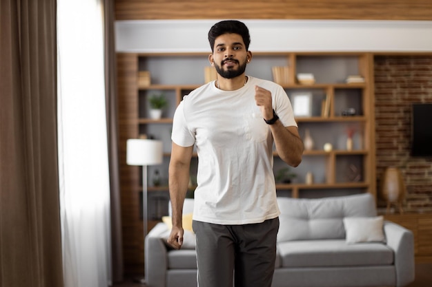 Arabische man die actieve fitnessoefeningen maakt in de woonkamer