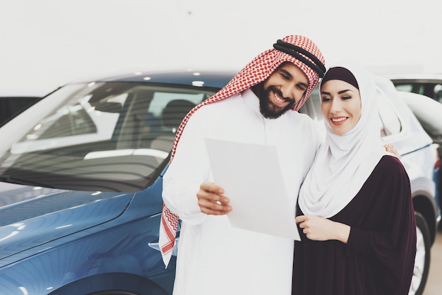 Arabische man houdt auto contract cadeau voor gelukkige vrouw.