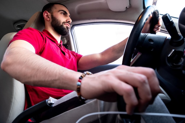 Arabische man rijdt met een glimlach in zijn auto en voelt zich zelfverzekerd