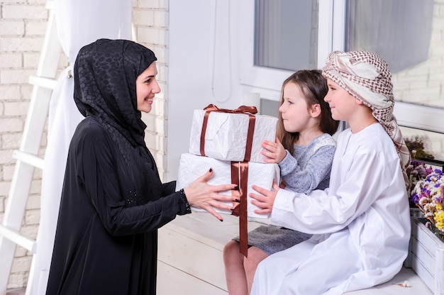 Arabische moeder en kinderen poseren met cadeau.