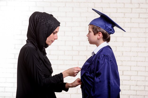 Arabische moeder poseren met afgestudeerde zoon