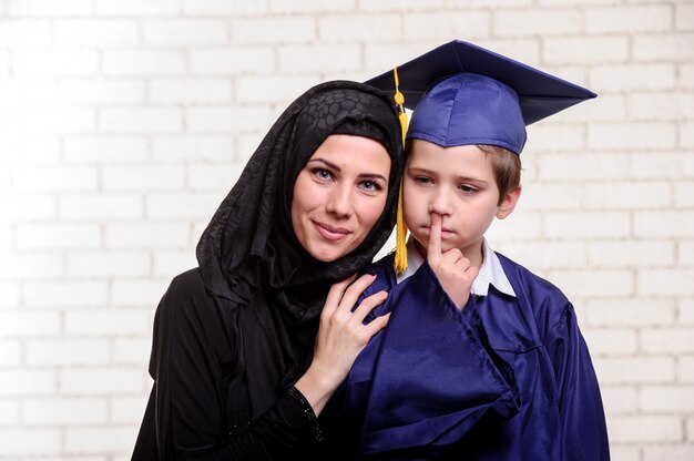 Arabische moeder poseren met afgestudeerde zoon