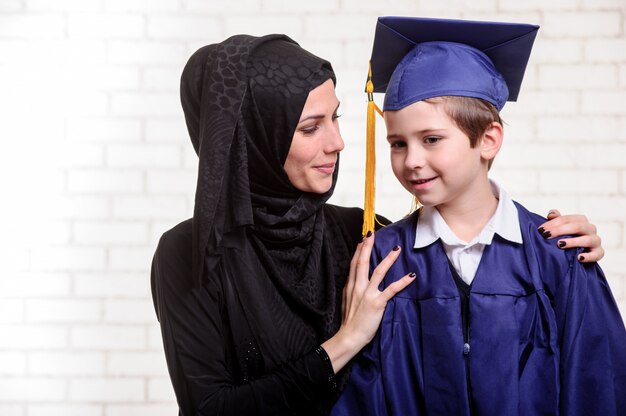 Arabische moeder poseren met afgestudeerde zoon