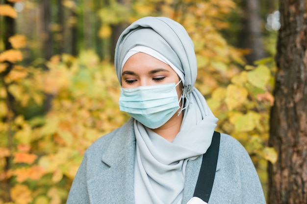 Arabische moslimvrouw die gezichtsmasker draagt om zichzelf buitenshuis te beschermen tegen coronavirus