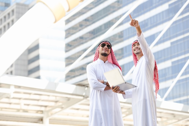 Arabische telefoon van de bedrijfsmensenvraag die aan taplet in de stad werken