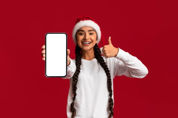 Arabische Vrouw In Kerstmanhoed Die Lege Smartphone Tonen En Duim Omhoog Gebaren