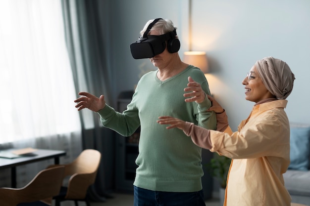 Foto arabische vrouw leert senior man spelen met virtual reality