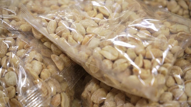 Arachis in verpakt plastic in een supermarkt Verpakking van verschillende soorten noten op het raam Groot plan snackconcept van gezonde voeding