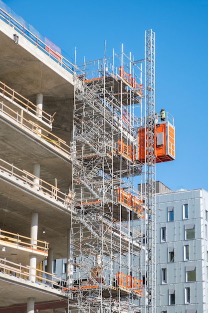 Arbeider die aan structuur van steiger werkt